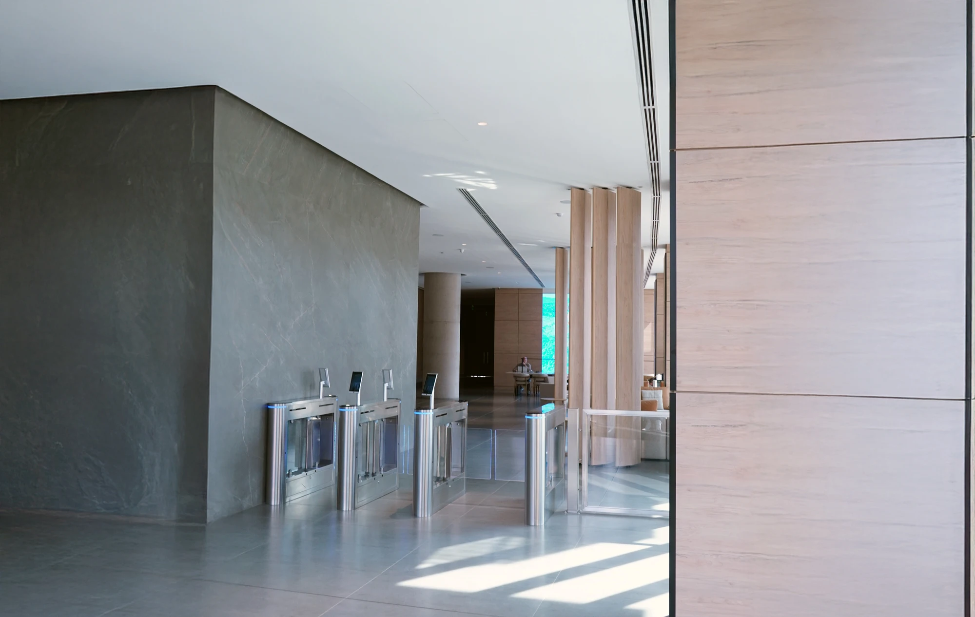 Acceso de edificio con torniquetes y muro de piedra